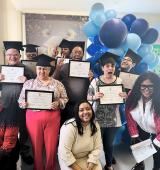Group of people celebrating graduation from therapy, they are wearing mortars and holding certificates