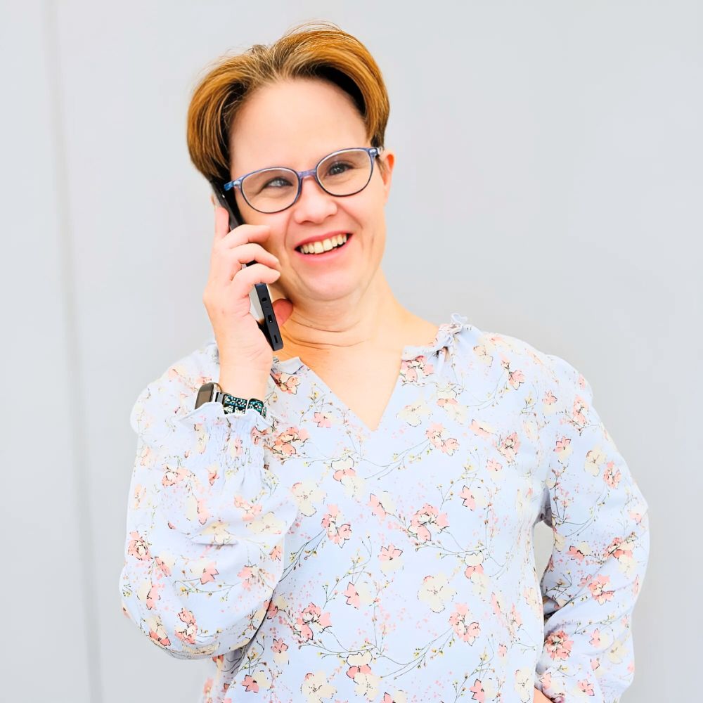 Janice McPillips smiles with a phone in her hand