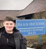 Luke stands outside his school in Long Island
