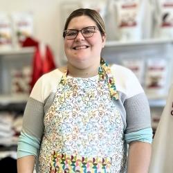 Ashley Tyrie stands in an apron in a her cooking class