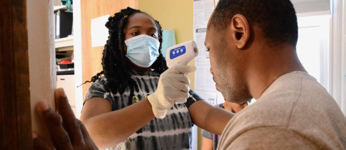 YAI Nurse in a residence takes the temperature of a resident