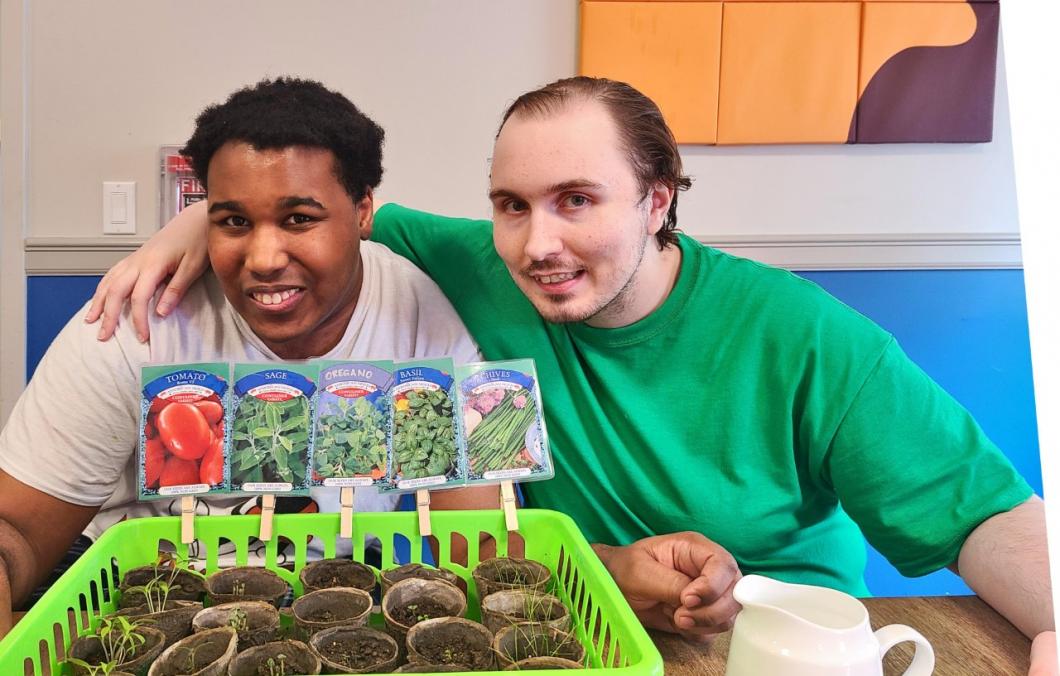 Two people hugging and showing their plants