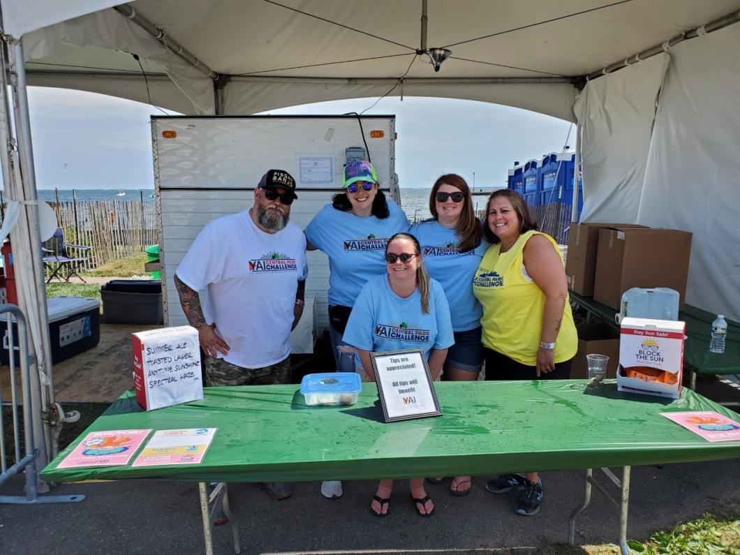 Group of 5 people pose for photo at festival table