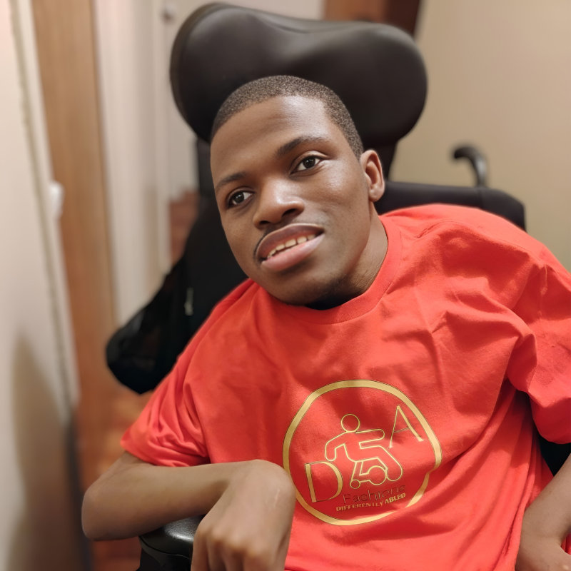 Maurice in a red shirt in a wheelchair.