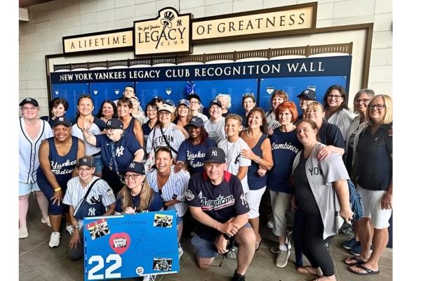 large group of people post at Yankee Stadium