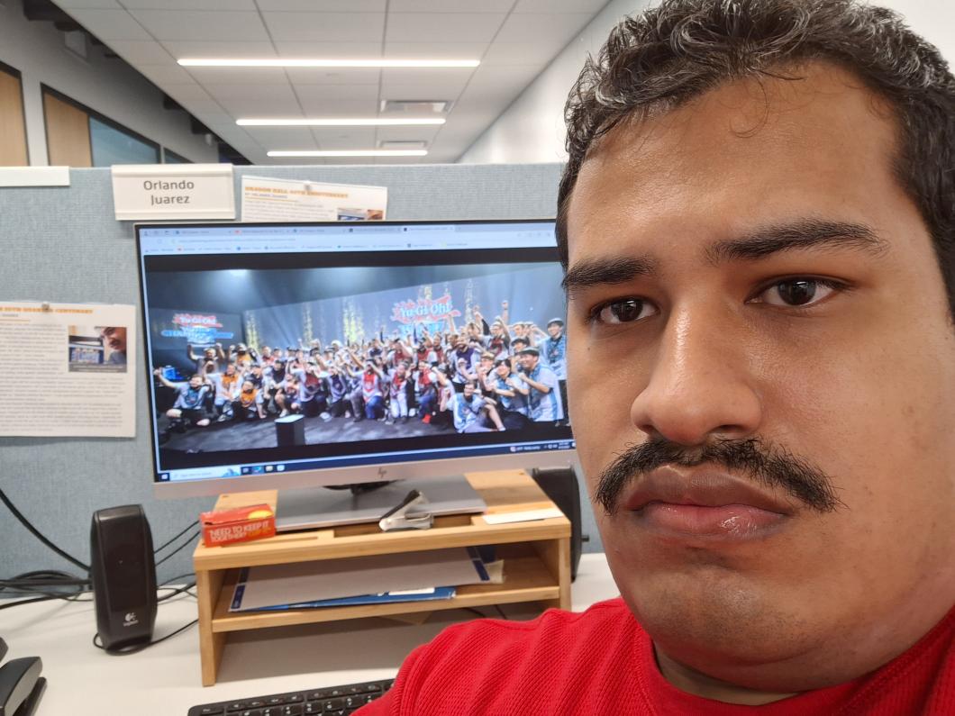 Selfie of a man with a monitor in the background.